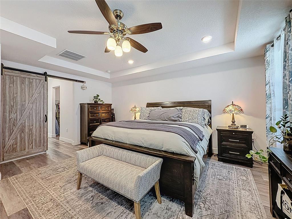 237 Leafy Way Avenue Spring Hill, FL 34606 - Photo 27 of 68 a bedroom with bed and a chandelier
