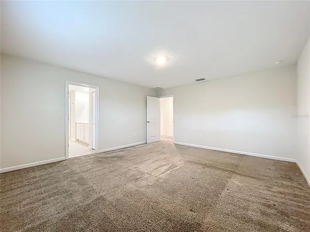 a view of an empty room with wooden floor and window