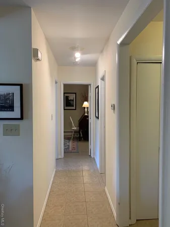 a view of a hallway with a livingroom and a bathroom
