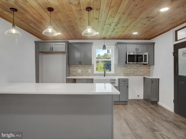 a large kitchen with stainless steel appliances a large counter top