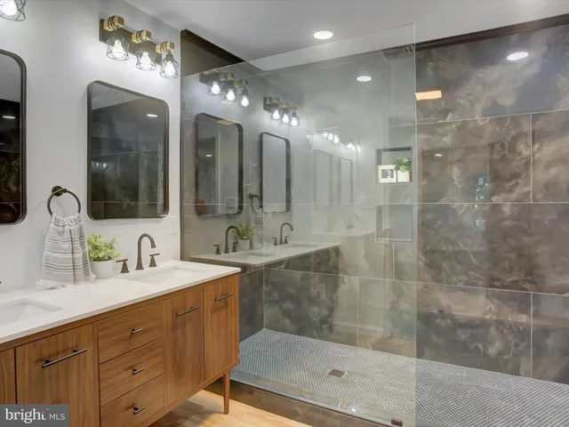 a bathroom with a double vanity sink mirror and shower