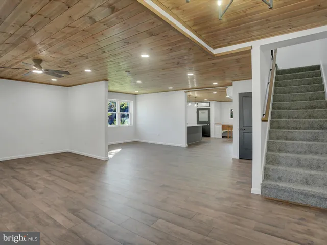 a view of a livingroom with wooden floor and stairs
