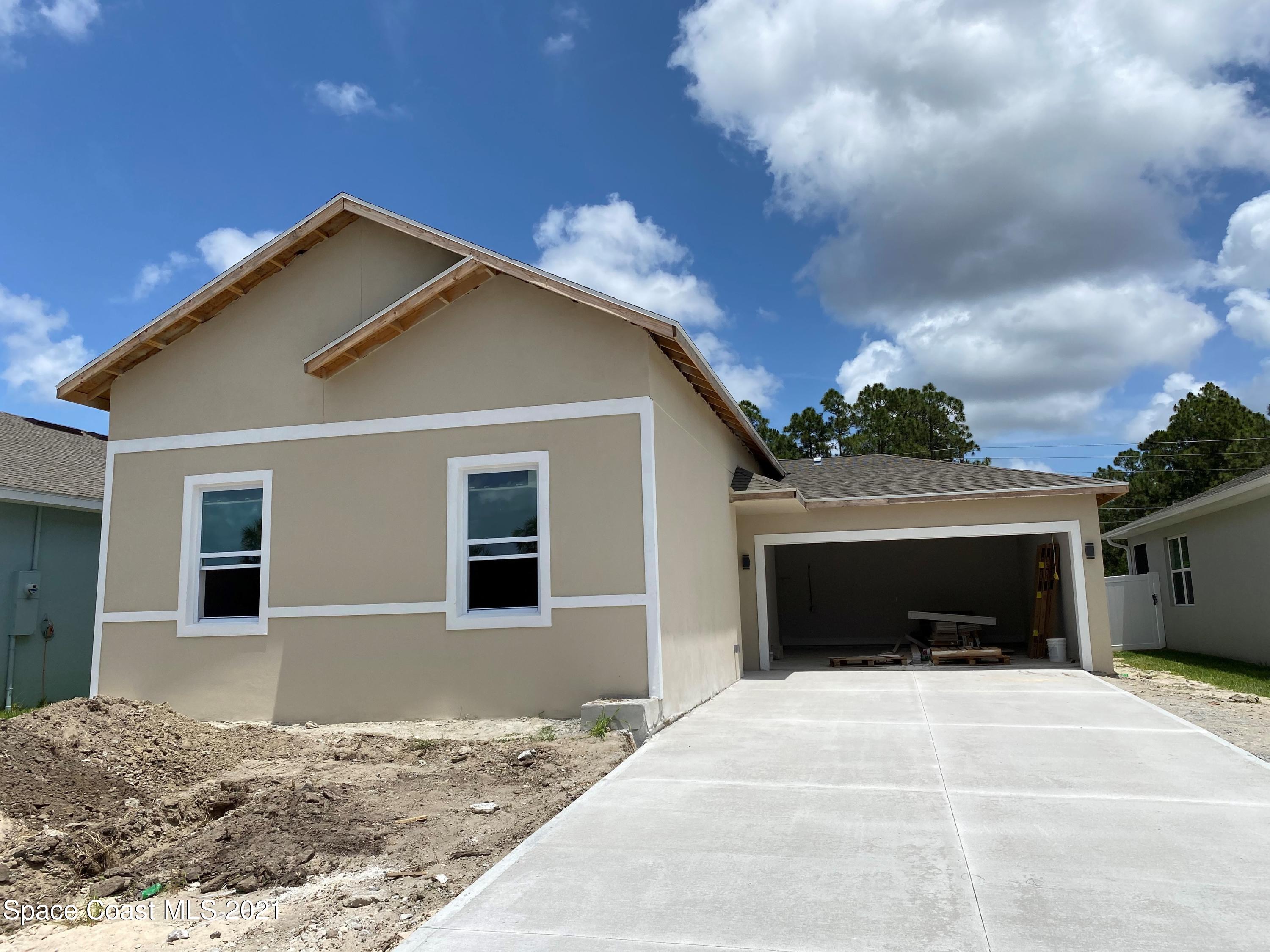 572 Corbin Circle Southwest Palm Bay, FL 32908 - Photo 1 of 32 a front view of a house with a yard and garage