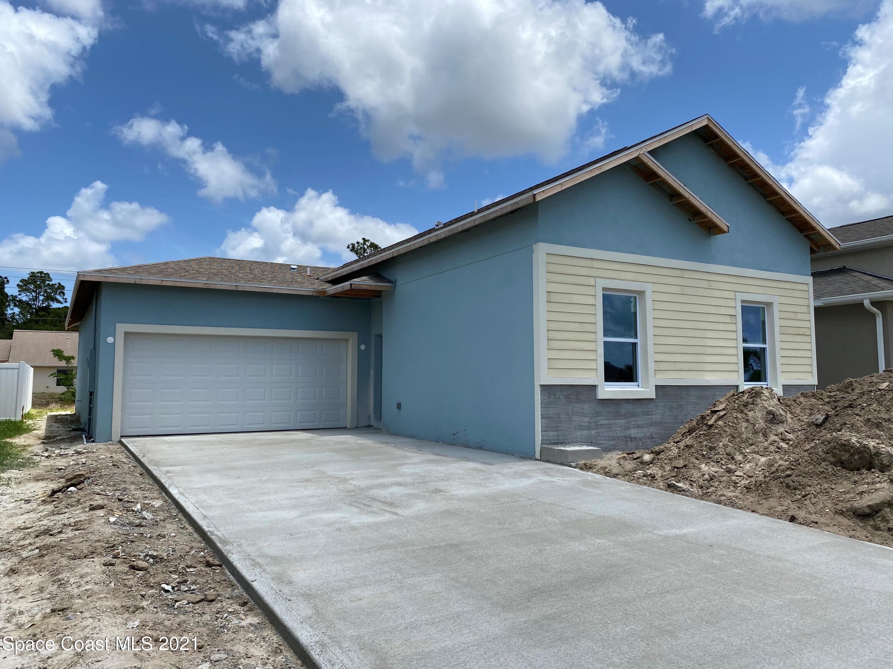 572 Corbin Circle Southwest Palm Bay, FL 32908 - Photo 2 of 32 a front view of a house with a yard and garage