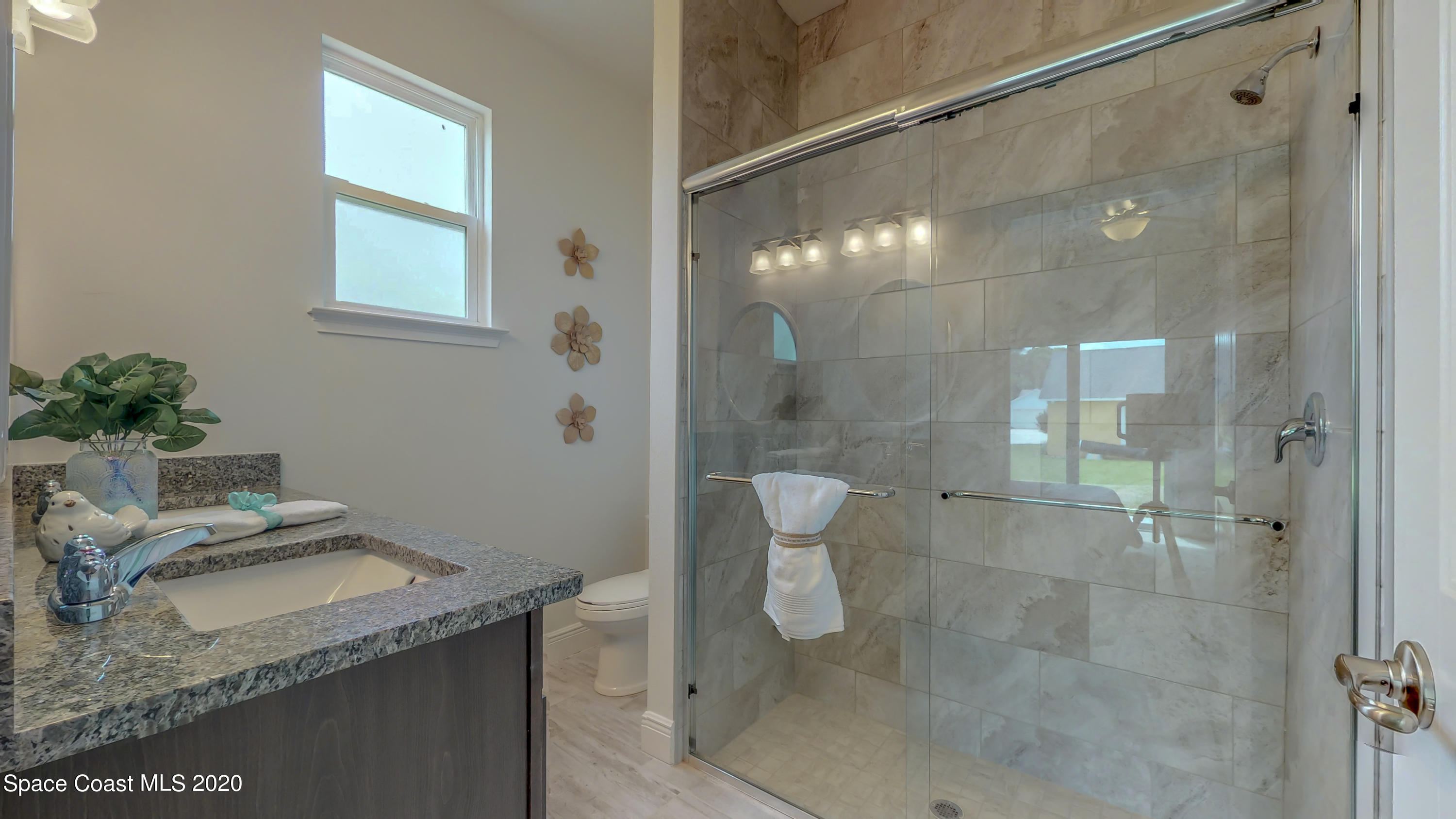 572 Corbin Circle Southwest Palm Bay, FL 32908 - Photo 11 of 32 a bathroom with a granite countertop sink a toilet and shower