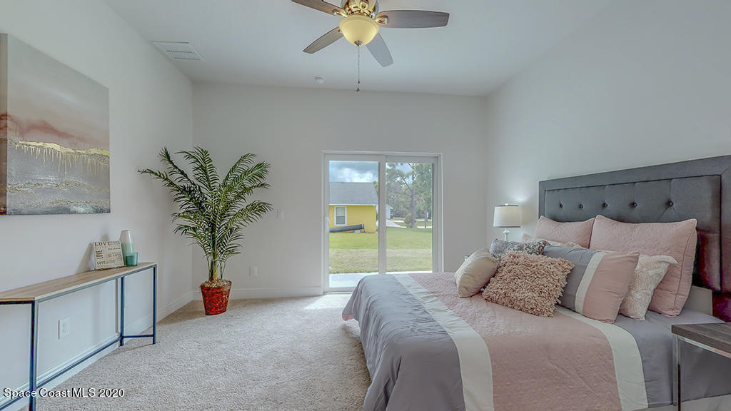572 Corbin Circle Southwest Palm Bay, FL 32908 - Photo 13 of 32 a bedroom with a large bed and a potted plant