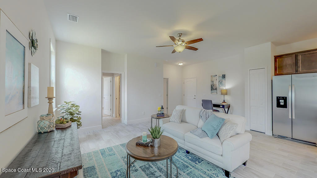572 Corbin Circle Southwest Palm Bay, FL 32908 - Photo 15 of 32 a living room with furniture a chandelier and a dining room