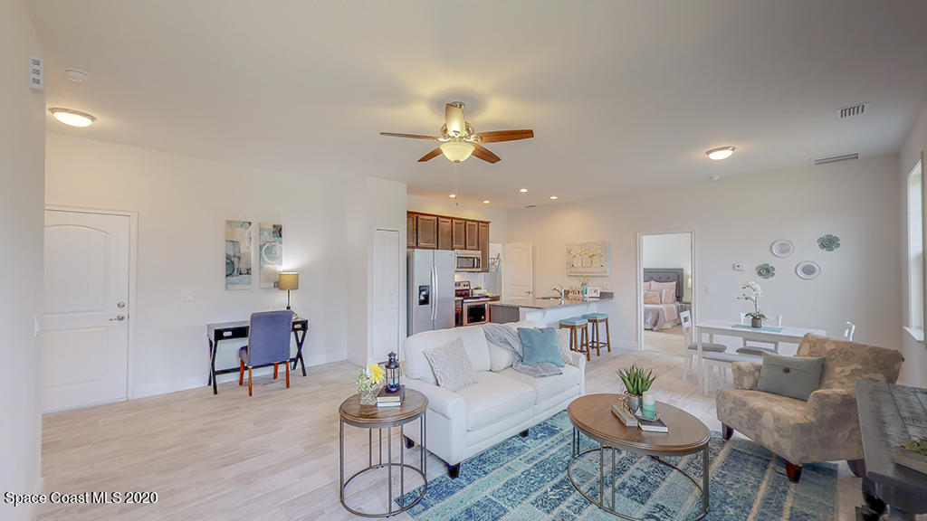 572 Corbin Circle Southwest Palm Bay, FL 32908 - Photo 17 of 32 a living room with furniture a chandelier and a rug