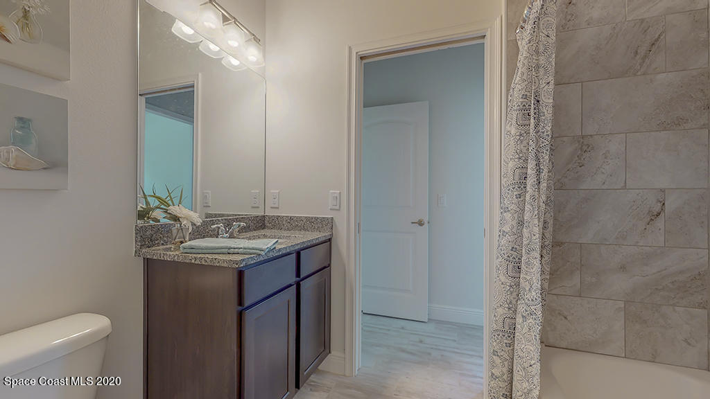 572 Corbin Circle Southwest Palm Bay, FL 32908 - Photo 19 of 32 a bathroom with a granite countertop sink a toilet and a mirror