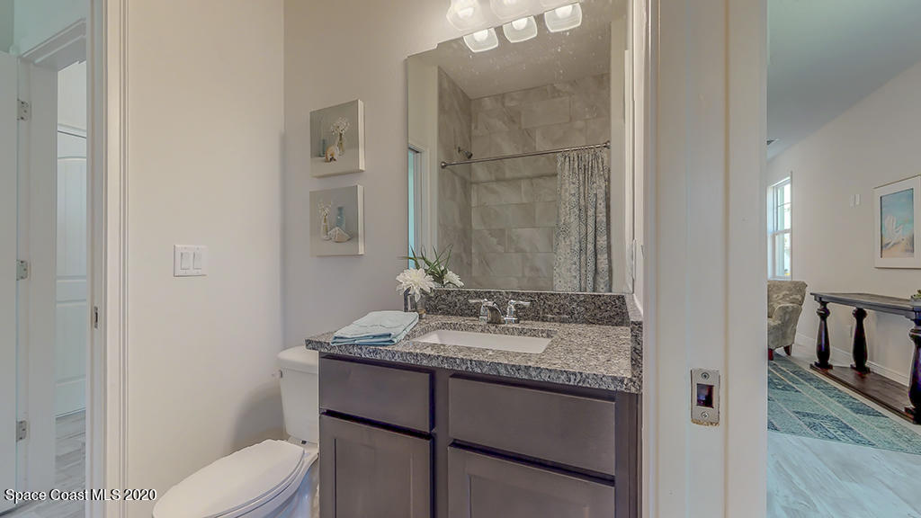 572 Corbin Circle Southwest Palm Bay, FL 32908 - Photo 22 of 32 a bathroom with a granite countertop sink toilet and mirror