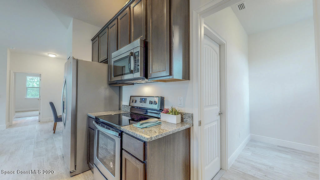 572 Corbin Circle Southwest Palm Bay, FL 32908 - Photo 26 of 32 a kitchen with stainless steel appliances granite countertop a stove and a refrigerator