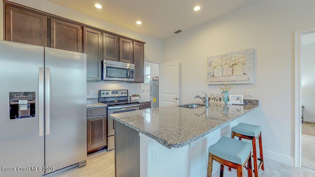 572 Corbin Circle Southwest Palm Bay, FL 32908 - Photo 5 of 32 a kitchen with stainless steel appliances granite countertop a sink refrigerator and microwave