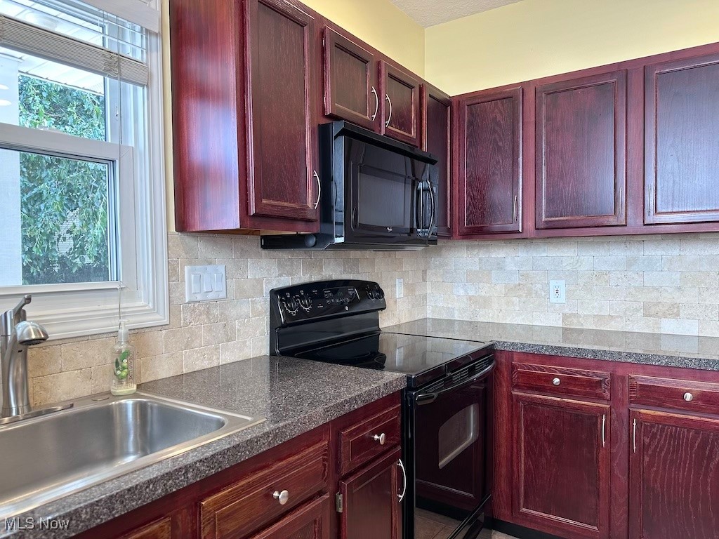 6846 Ottawa Road Cleveland, OH 44105 - Photo 22 of 50 Kitchen featuring decorative backsplash, black appliances, reddish brown cabinets, and a sink