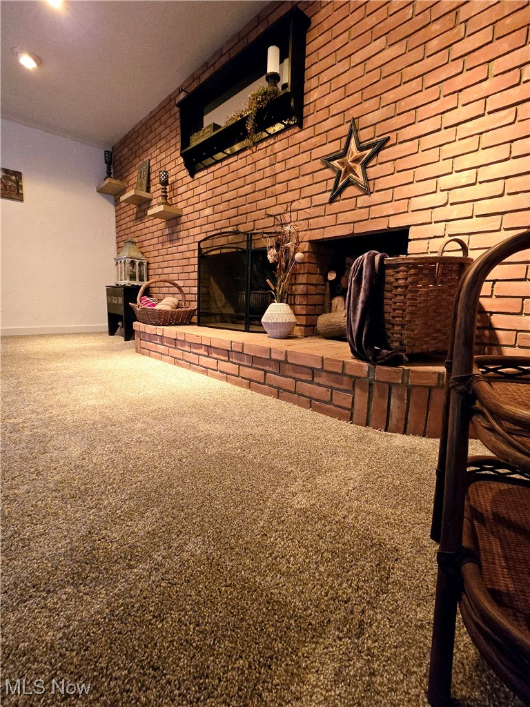 1550 North County Line Road Geneva, OH 44041 - Photo 25 of 47 Family room featuring brick wall, new carpet flooring, and a fireplace
