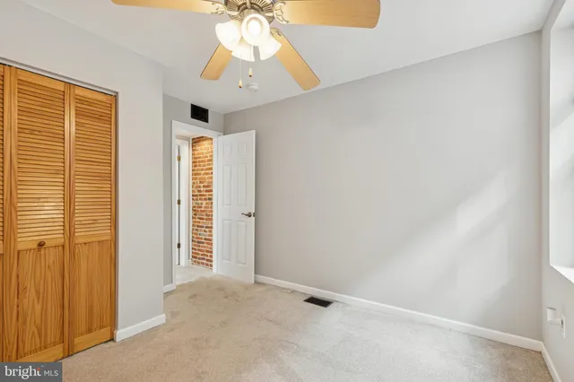 an empty room with chandelier fan