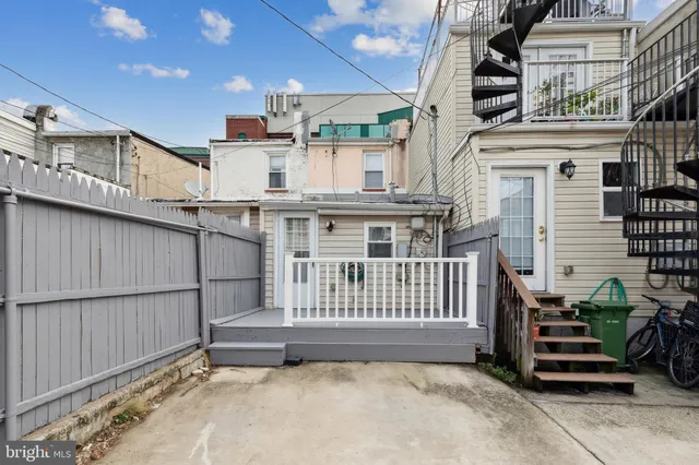a view of a white house with iron fence