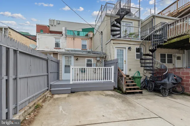 a view of a house with a small yard and wooden fence