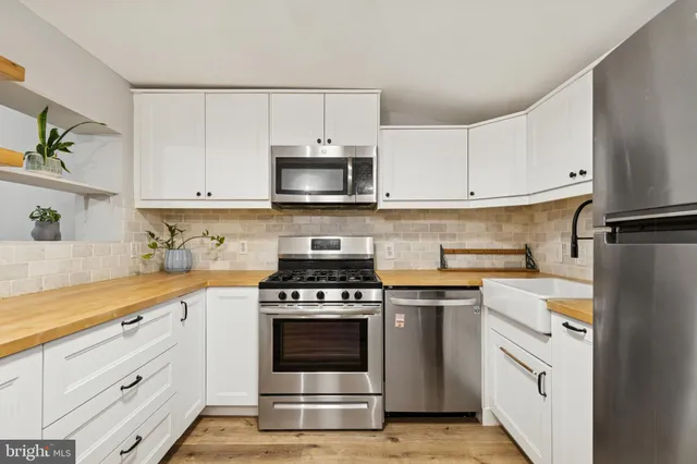 a kitchen with white cabinets and stainless steel appliances