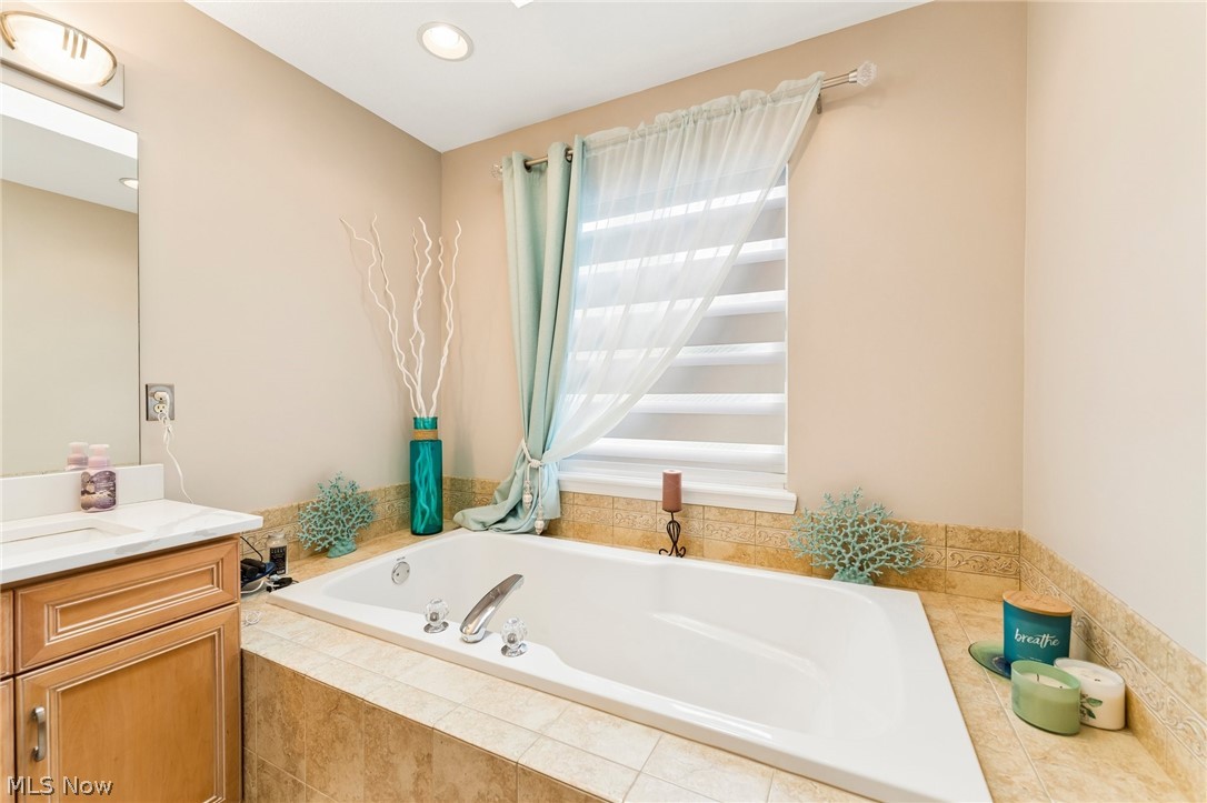 8874 Sharp Road Olmsted Falls, OH 44138 - Photo 21 of 42 Built-in soaking tub with tile surround and an integrated window featuring sheer drapery