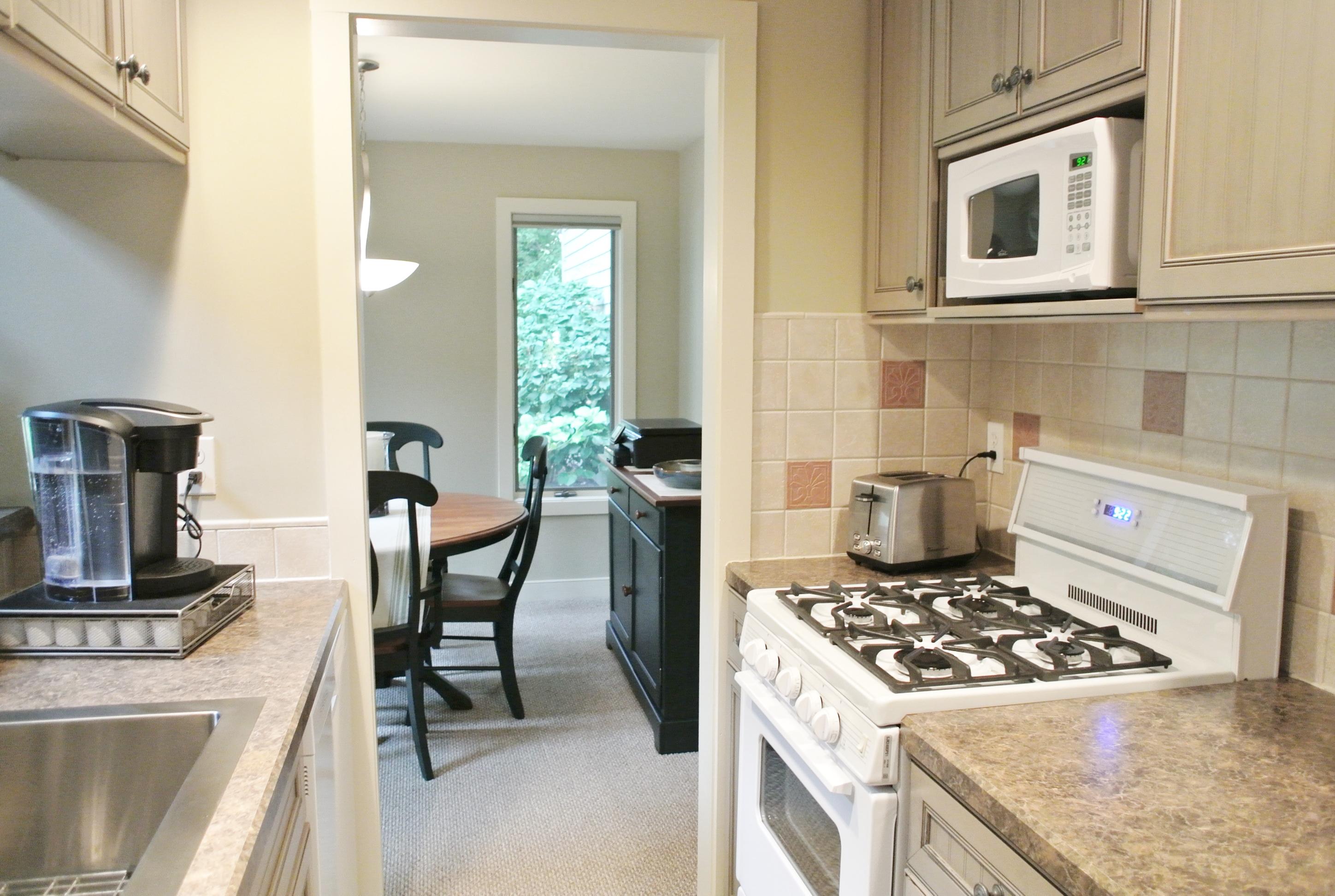 22 Mid-Iron Way, Unit 7509 Mashpee, MA 02649 - Photo 14 of 32 a kitchen with kitchen island a stove a sink and a refrigerator