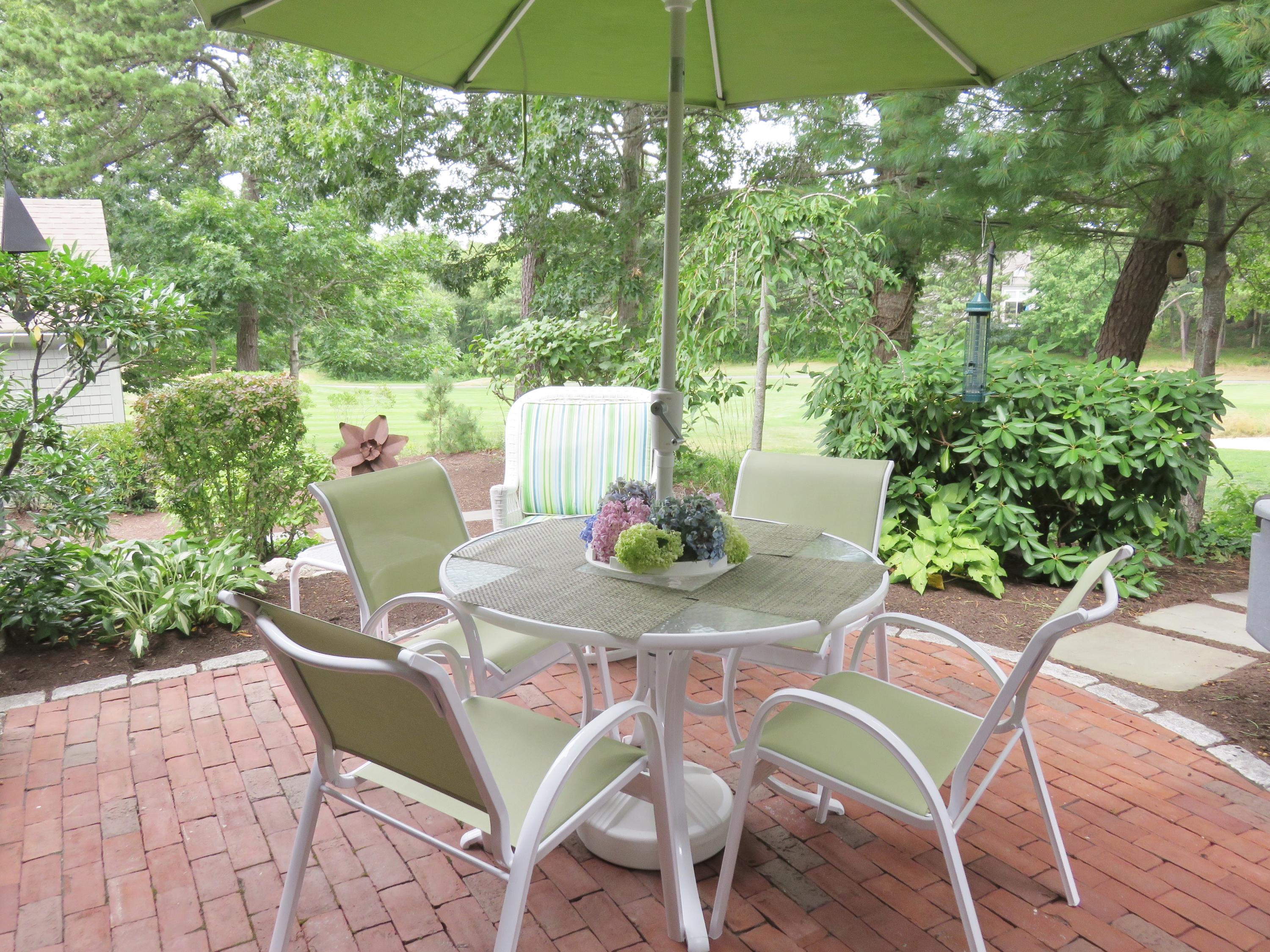 22 Mid-Iron Way, Unit 7509 Mashpee, MA 02649 - Photo 6 of 32 a table and chairs in the patio