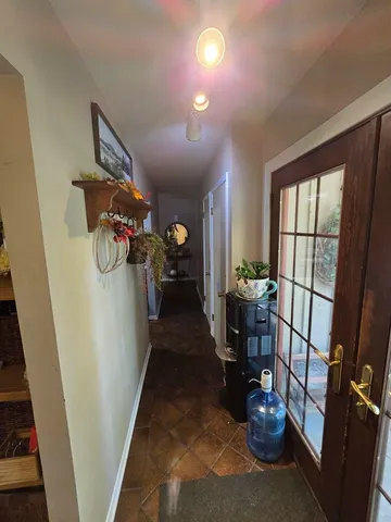 a hallway with wooden floor a fireplace and a potted plant