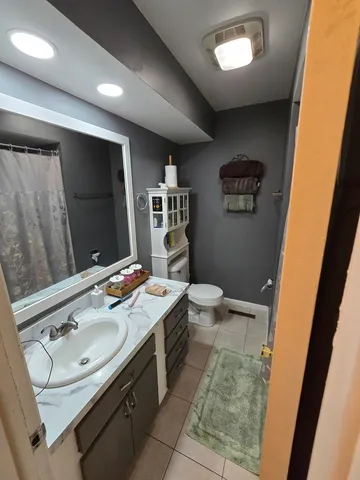 a bathroom with a sink mirror vanity and toilet