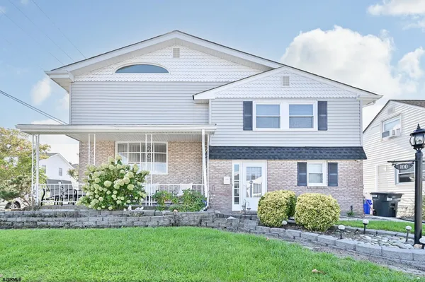 a front view of a house with a garden and plants
