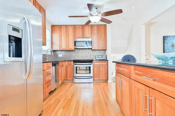 a kitchen with stainless steel appliances granite countertop a stove a sink and a refrigerator
