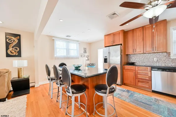 a large kitchen with kitchen island a large counter top space a sink stainless steel appliances and cabinets