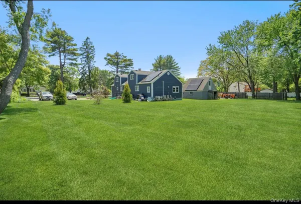 a front view of a house with a yard and trees