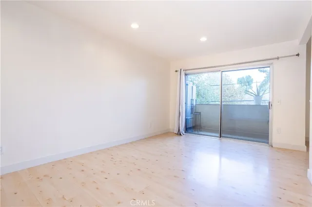 an empty room with wooden floor and sliding door