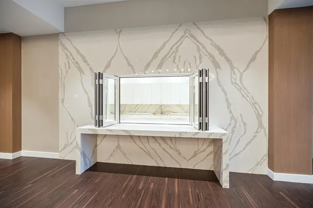 a view of a big room with wooden floor and windows