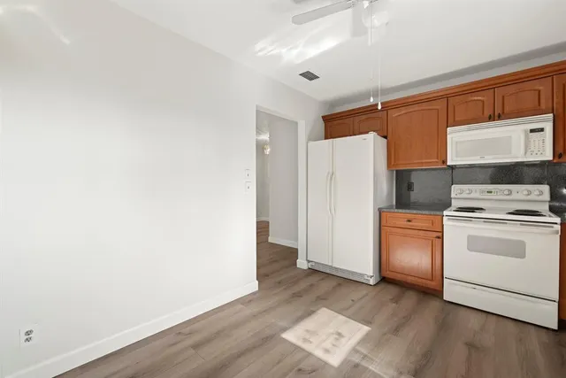 a kitchen with a refrigerator and a stove top oven