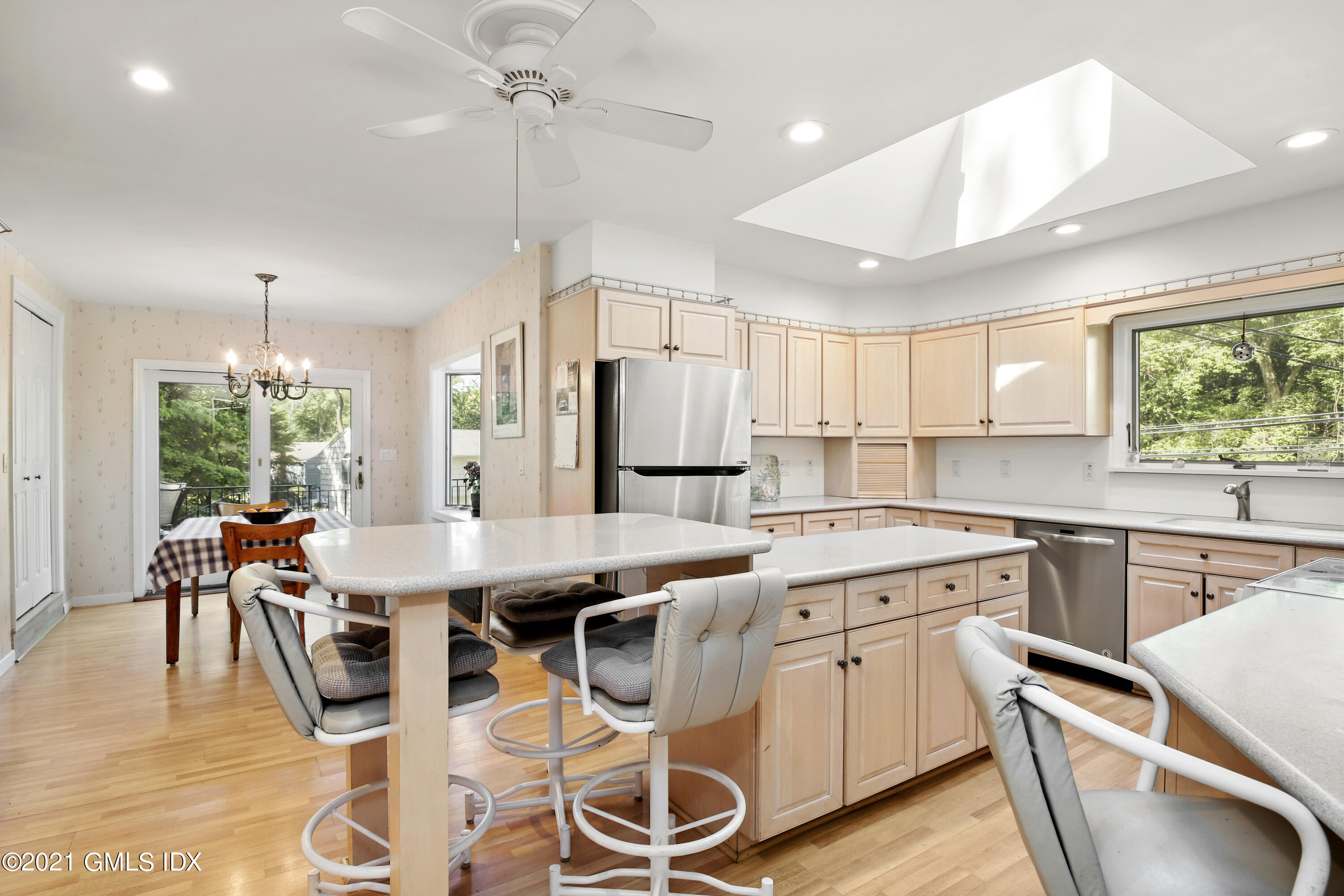 6 Old Orchard Road Riverside, CT 06878 - Photo 6 of 26 a open kitchen with stainless steel appliances granite countertop a stove top oven a sink dishwasher a dining table and chairs with wooden floor