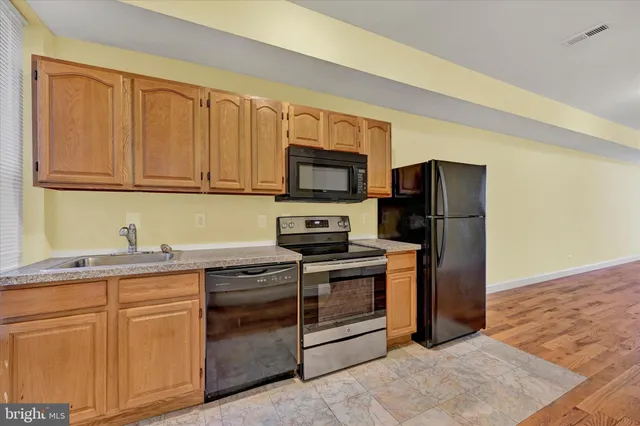 a kitchen with stainless steel appliances granite countertop a refrigerator stove and sink