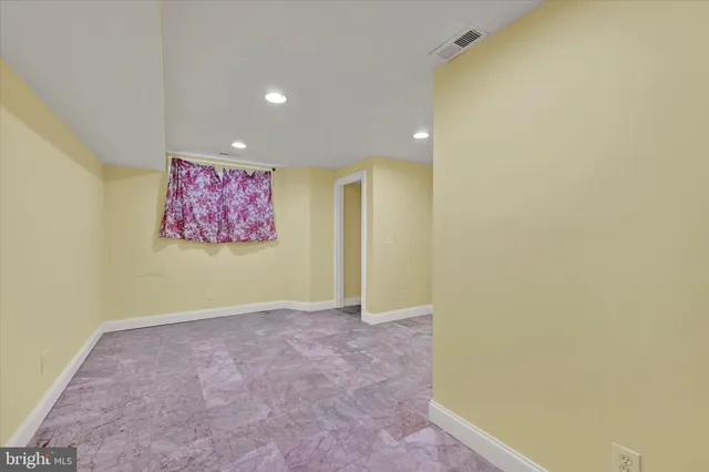 an empty room with wall painting and a lamp