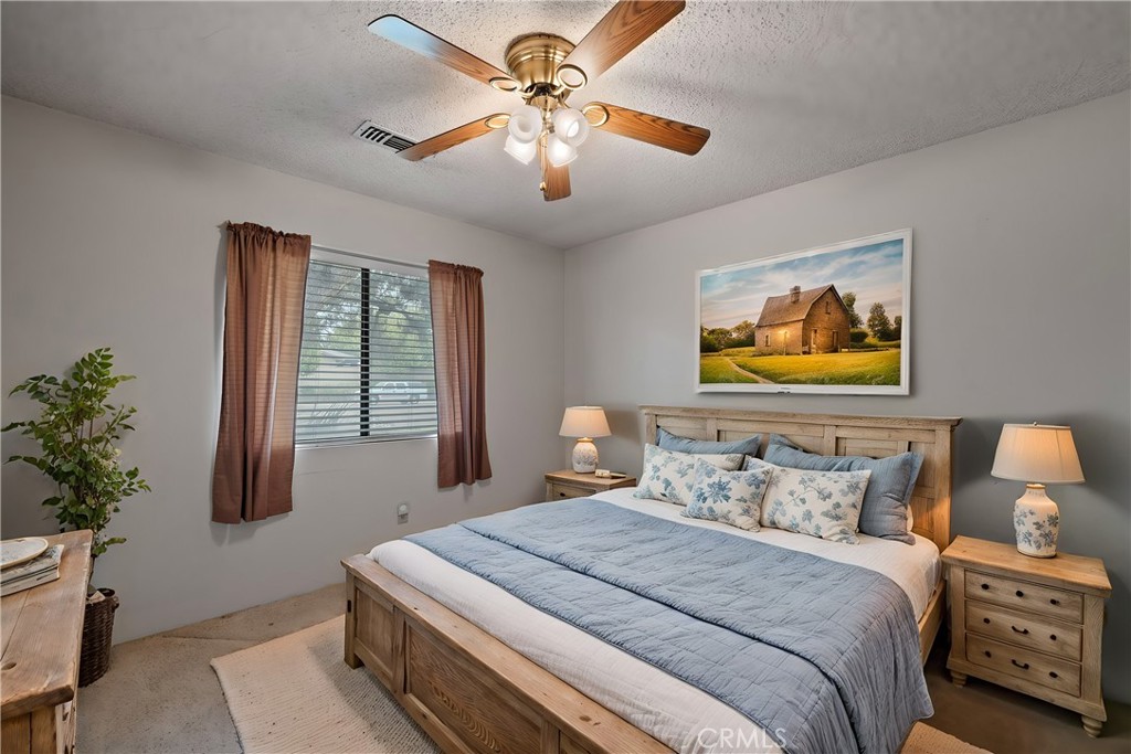 2065 Jenkins Road Bakersfield, CA 93314 - Photo 26 of 59 a bedroom with a bed and a chandelier