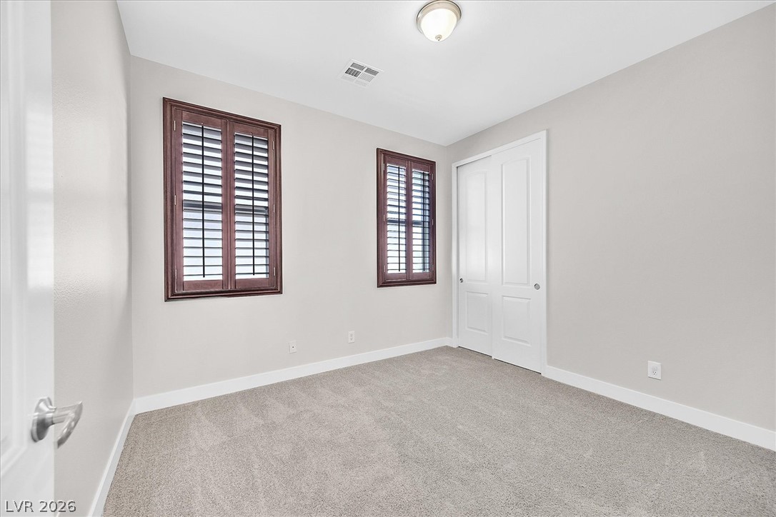 2447 Kaymin Ridge Road Henderson, NV 89052 - Photo 22 of 40 Rich wood shutters and plush carpeting define this versatile guest bedroom.