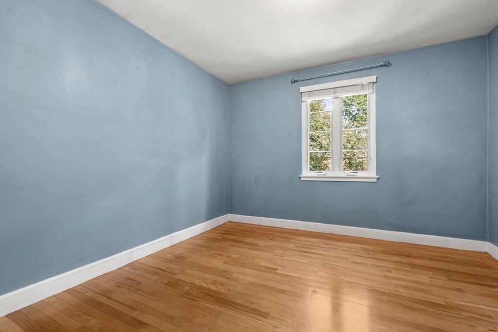 57 Pierce Road, Unit 57 Watertown, MA 02472 - Photo 16 of 22 a view of an empty room with wooden floor and a window