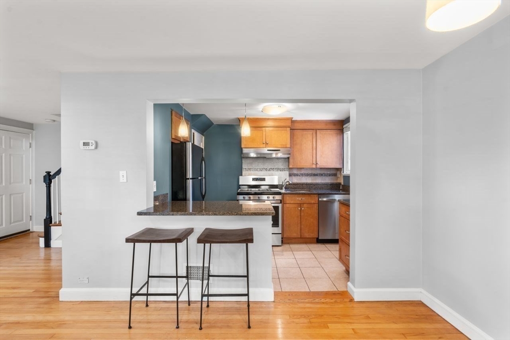 57 Pierce Road, Unit 57 Watertown, MA 02472 - Photo 3 of 22 a kitchen with stainless steel appliances kitchen island granite countertop a refrigerator and a stove top oven
