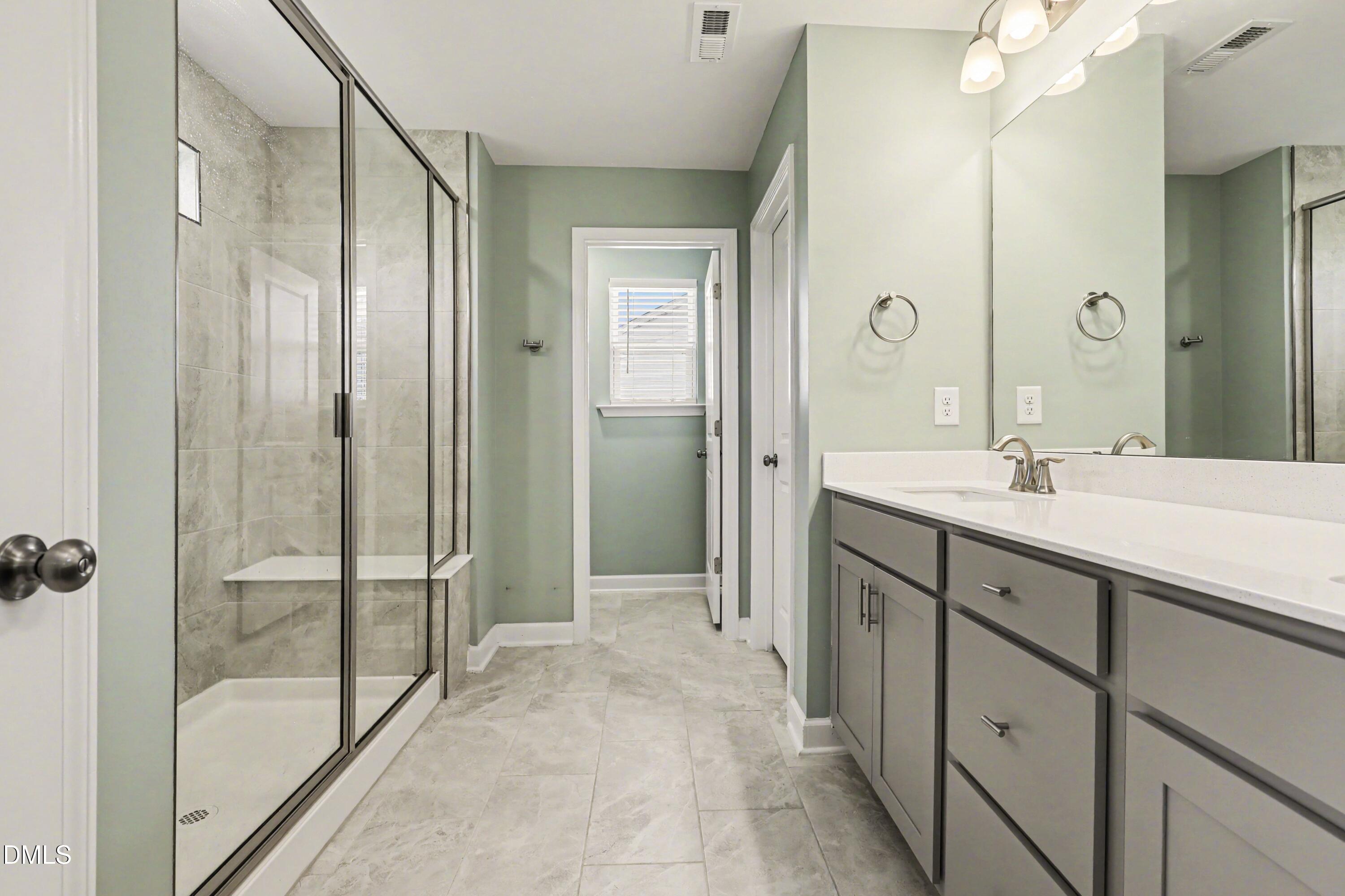 90 Rigsby Avenue Four Oaks, NC 27524 - Photo 15 of 43 a spacious bathroom with a shower sink and mirror