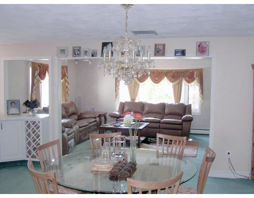 39 Locust Street Burlington, MA 01803 - Photo 4 of 5 a view of dining room and livingroom with furniture wooden floor a rug and a chandelier