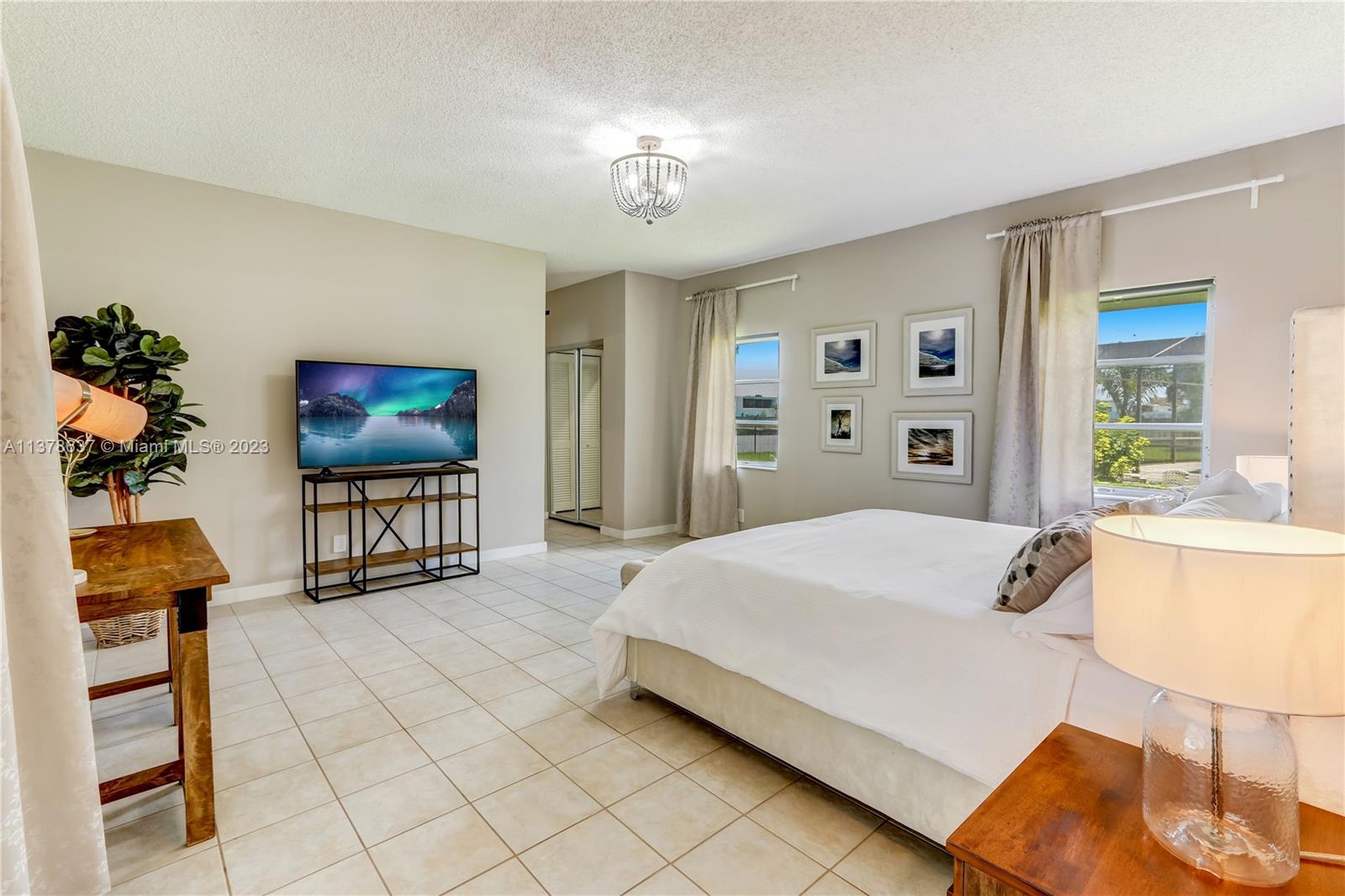 Bonaventure Lakes Weston, FL 33326 - Photo 35 of 52 a spacious bedroom with a bed and a chandelier