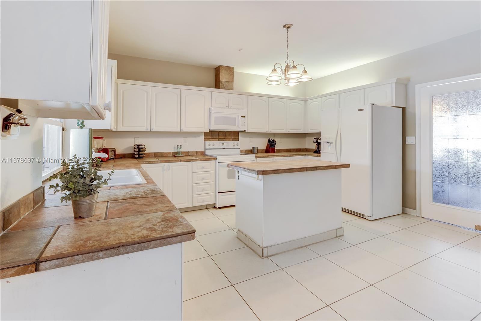 Bonaventure Lakes Weston, FL 33326 - Photo 10 of 52 a kitchen with kitchen island granite countertop a stove a sink a refrigerator a counter top space and cabinets
