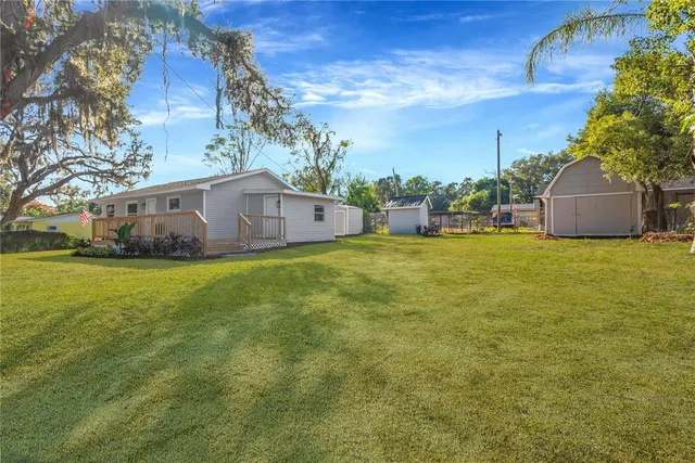 a view of a house with a big yard and potted plants