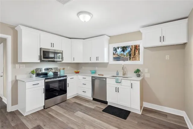 a kitchen with stainless steel appliances granite countertop a stove a sink and a microwave