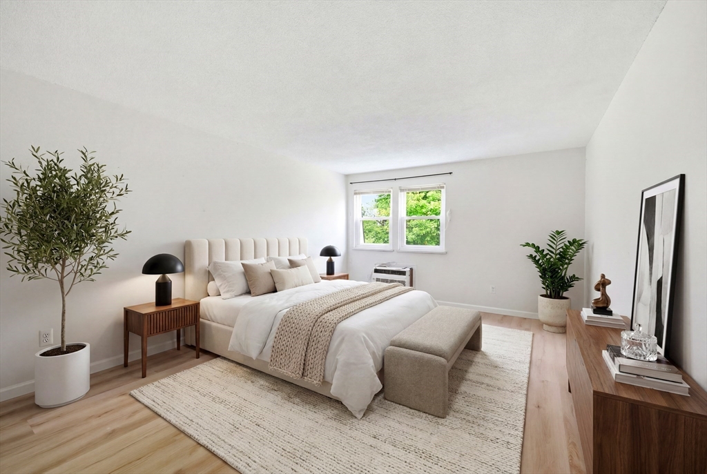 80 Damon Road, Unit 2303 Northampton, MA 01060 - Photo 16 of 23 a bedroom with a bed and a potted plant on the dresser