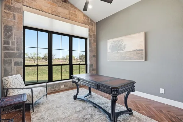 a living room with a table chair and a large window