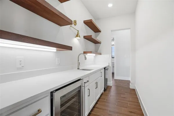 a kitchen with a sink and wooden floor